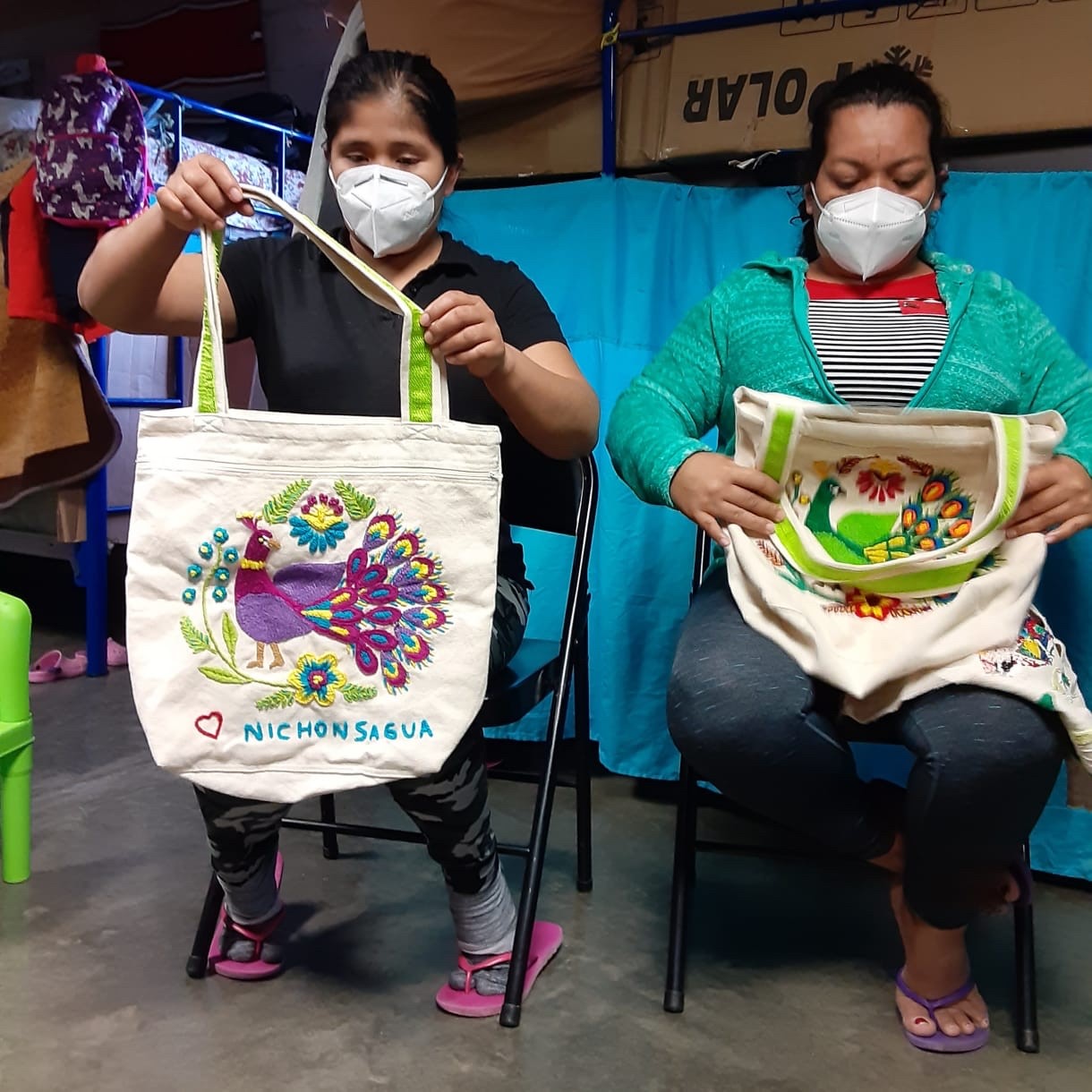 Women from the Embroidery Project showing their tote bags