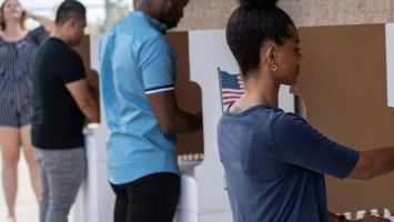 People casting their ballots in voting booths