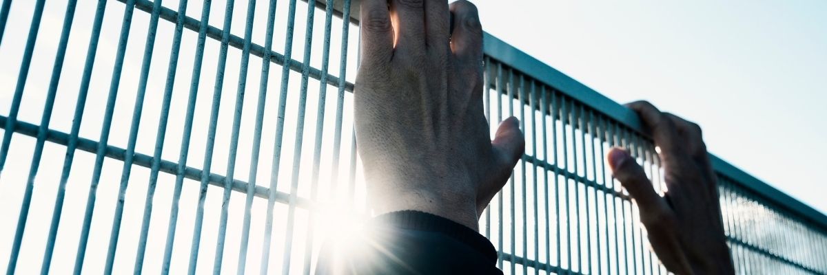 Close up of man blocked by a fence