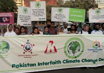 People hold signs during ecological protest in Pakistan